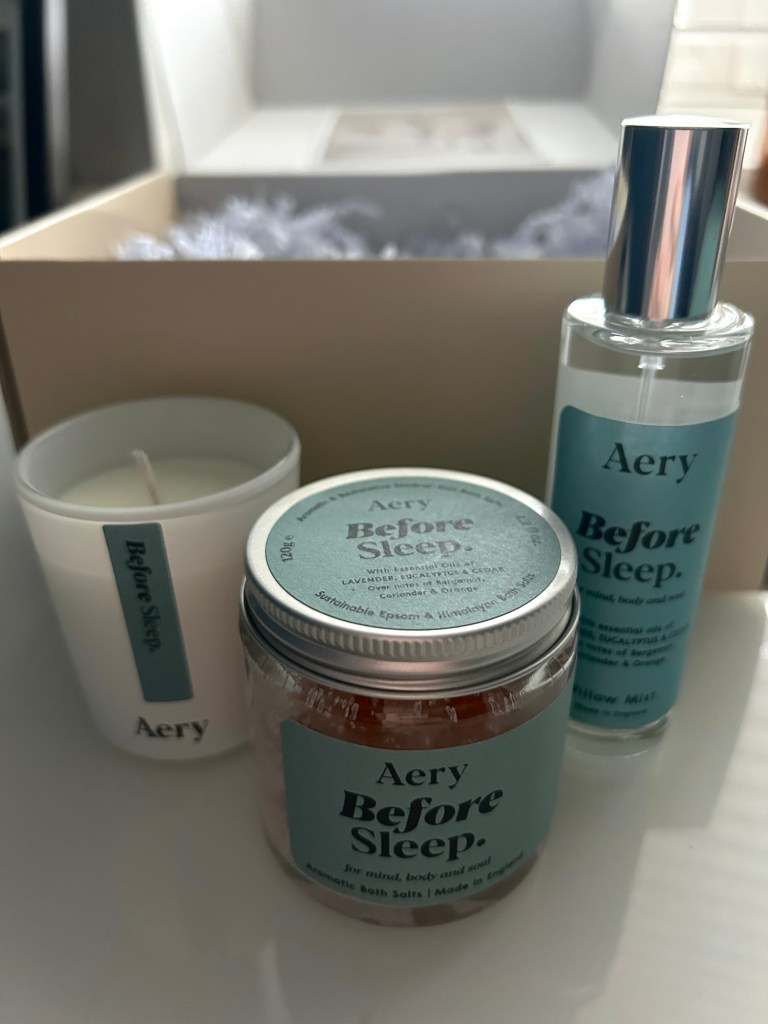 Candle, bath salts and pillow mist spray placed together